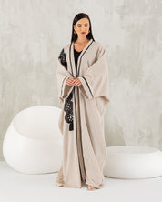 Beige linen abaya with black trims.