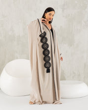 Beige linen abaya with black trims.