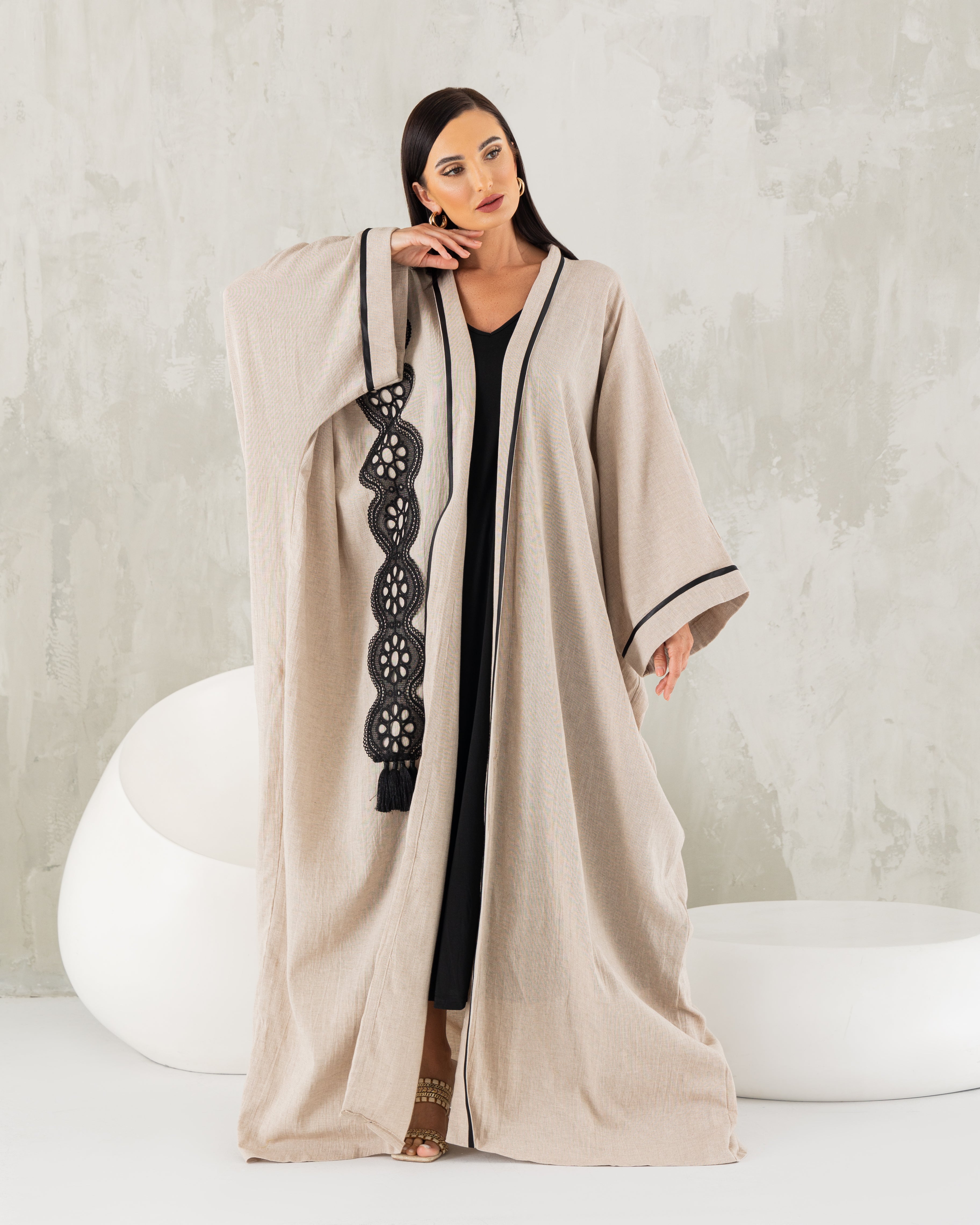 Beige linen abaya with black trims.